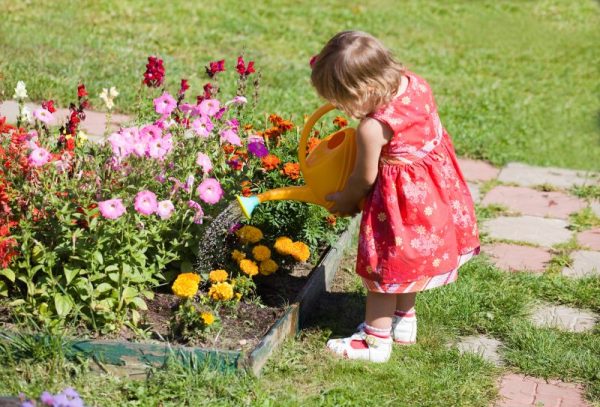 una bambina gioca all'aperto con i fiori