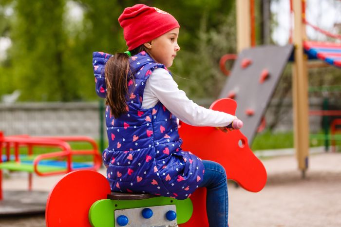 bambina gioca al parco giochi