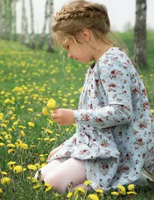 bambina che gioca sui prati fioriti in primavera