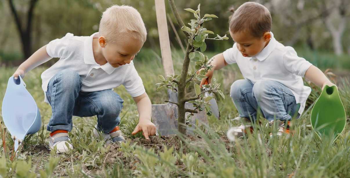 Due bambini piantano semi nella terra